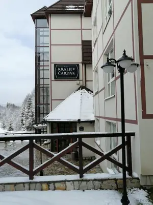a building with a fence and a street light in the snow at Kraljevi čardaci, apartman 53 u zgradi 7, opcija unutrašnjeg parking mesta in Kopaonik