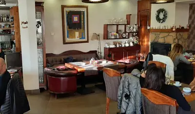 a group of people sitting at a table in a restaurant at Kraljevi čardaci, apartman 53 u zgradi 7, opcija unutrašnjeg parking mesta in Kopaonik