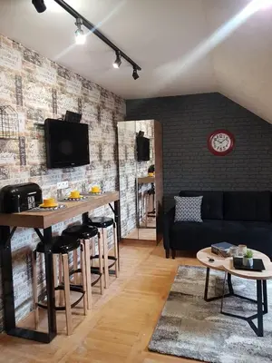 a living room with a couch and a table at Kraljevi čardaci, apartman 53 u zgradi 7, opcija unutrašnjeg parking mesta in Kopaonik