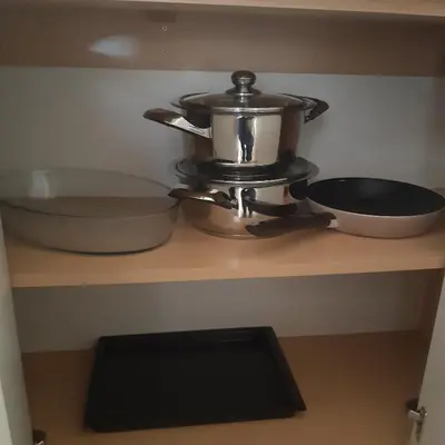 a kitchen shelf with two pots and pans on it at Apartman Marger in Niš