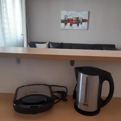 a microwave sitting under a table with a coffee maker at Apartman Marger in Niš