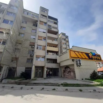 a tall apartment building with people standing in front of it at Apartman Marger in Niš