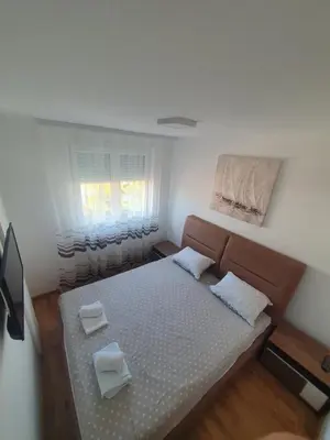 a small bedroom with a bed and a window at Nina Apartman in Soko Banja