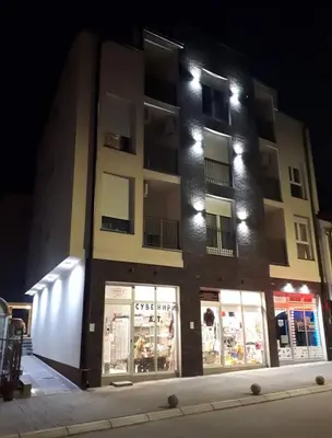 a building with a store in front of it at night at Nina Apartman in Soko Banja