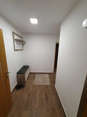 an empty room with a white wall and wooden floors at Nina Apartman in Soko Banja