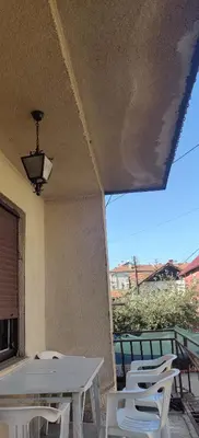 a group of white tables and chairs on a patio at Hostel Golub in Zaječar