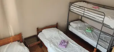 two bunk beds in a room with white sheets at Hostel Golub in Zaječar