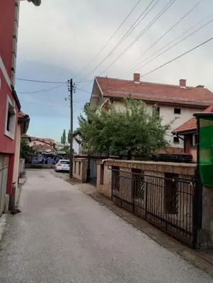 an empty street with a house and a fence at Hostel Golub in Zaječar