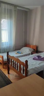 a bedroom with two beds and a window at Hostel Golub in Zaječar