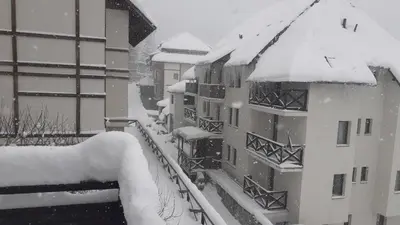 a snow covered balcony of a apartment building at Vikend kuća Čairović in Kopaonik