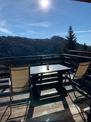 a table and chairs on a deck with a view at Vikend kuća Čairović in Kopaonik
