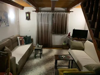 a living room with a couch and a tv at Vikend kuća Čairović in Kopaonik