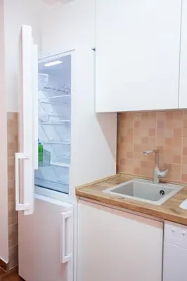 a kitchen with an empty refrigerator and a sink at Lux Family Apartment Vidanovic in Pirot