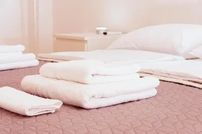 a pile of white towels on a bed at Lux Family Apartment Vidanovic in Pirot