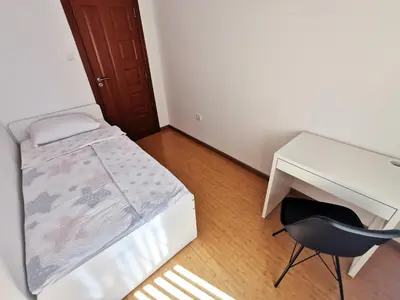 a bedroom with a bed and a desk and a chair at Lux Family Apartment Vidanovic in Pirot