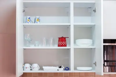 a white cabinet filled with plates and dishes at Lux Family Apartment Vidanovic in Pirot