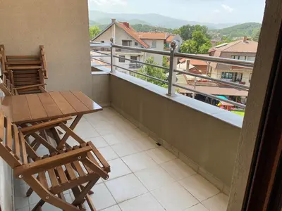 a balcony with two chairs and a table on a balcony at Apartman Luka in Vrnjačka Banja