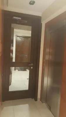 a bathroom with a door and a mirror in a room at Apartman A7 u vili Pahulja in Kopaonik