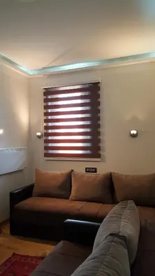 a brown couch in a living room with a window at Apartman A7 u vili Pahulja in Kopaonik