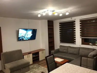 a living room with a couch and a tv on the wall at Apartman B3 u vili Suri in Kopaonik