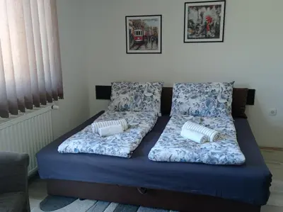 a bed with blue sheets and pillows on it at Apartman Sunce in Soko Banja