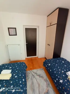 a bedroom with two beds and a closet and a door at Apartman Sunce in Soko Banja
