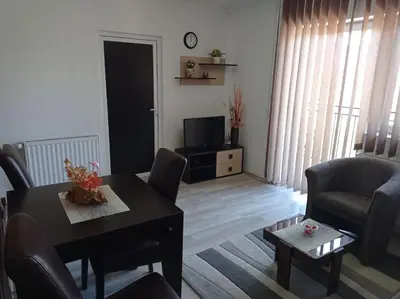 a living room with a table and chairs and a television at Apartman Sunce in Soko Banja