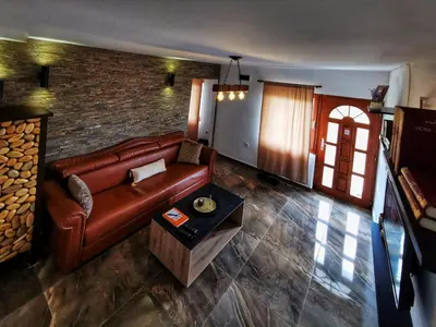 a living room with a leather couch and a brick wall at Villa Balconlux - Zavojsko jezero, Pirot in Pirot