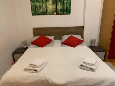 a bedroom with a large white bed with red pillows at Belvedere in Niš