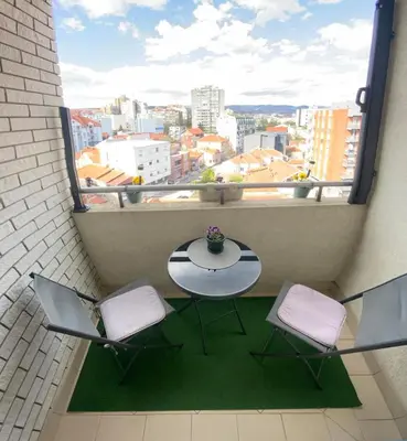 a balcony with a table and two chairs and a window at Belvedere in Niš