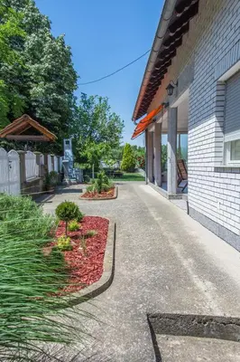 a walkway in front of a building with plants at Vila Čair in Balajnac