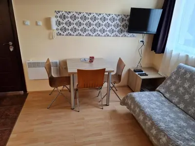 a living room with a table and chairs and a couch at Cosy apartment Marina in Kopaonik