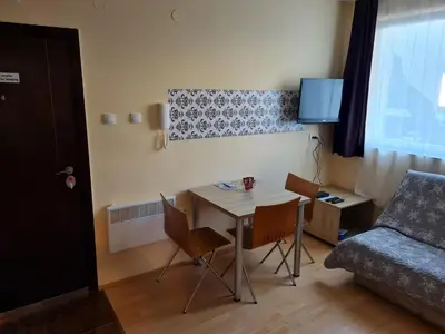 a small room with a table and chairs and a couch at Cosy apartment Marina in Kopaonik