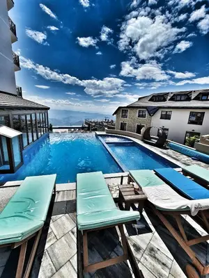a swimming pool with chaise lounge chairs on a building at Milmari S70 Kopaonik in Kopaonik