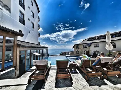 a group of people sitting in chairs next to a swimming pool at Milmari S70 Kopaonik in Kopaonik