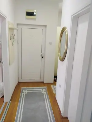 a hallway with a white door and a mirror at Rudolf apartmani in Soko Banja
