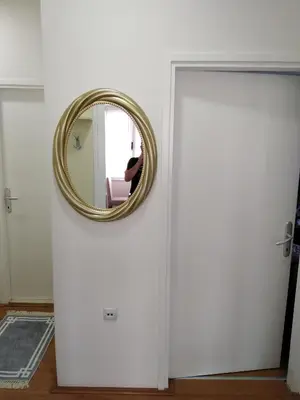 a mirror on a door with a person sitting in a chair at Rudolf apartmani in Soko Banja