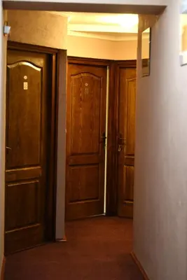 an empty hallway with wooden doors in a building at Etno kuca sa konacistem GOCKO in Vrnjačka Banja