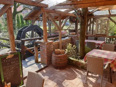 a pavilion with a table and chairs and a grill at Etno kuca sa konacistem GOCKO in Vrnjačka Banja