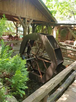a large wooden wheel sitting on top of a wooden bench at Etno kuca sa konacistem GOCKO in Vrnjačka Banja