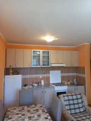 a kitchen with wooden cabinets and a white refrigerator at Apartmani Ivančica in Vrnjačka Banja