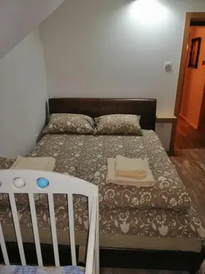 a bedroom with a bed and a crib in it at Apartman Daša in Soko Banja