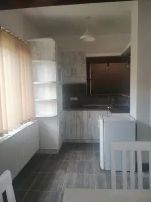 a kitchen with white cabinets and a table and chairs at Apartman Daša in Soko Banja