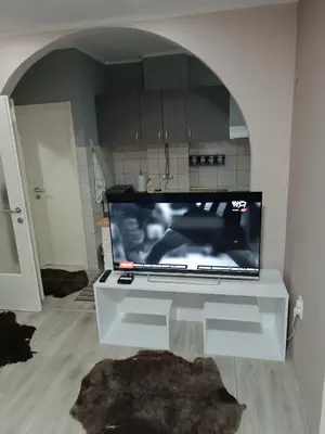 a tv sitting on a white table in a living room at Stan na dan in Aleksinac