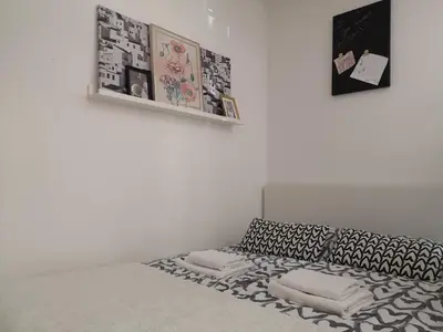 a white room with a couch with pillows and pictures at B3 Sneznik-Modern apartment in Vrnjačka Banja