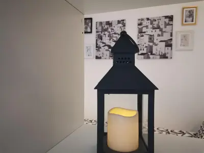 a black lantern with a yellow candle in a room at B3 Sneznik-Modern apartment in Vrnjačka Banja