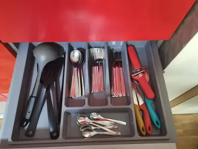 a drawer filled with utensils in a red container at B3 Sneznik-Modern apartment in Vrnjačka Banja