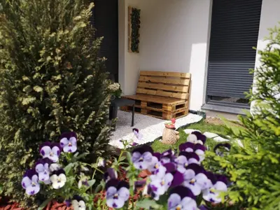 a garden with a christmas tree and a wooden bench at B3 Sneznik-Modern apartment in Vrnjačka Banja
