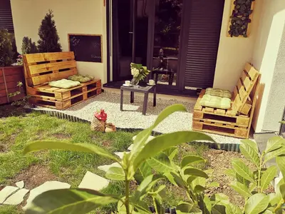 a patio with two chairs and a table in front of a door at B3 Sneznik-Modern apartment in Vrnjačka Banja