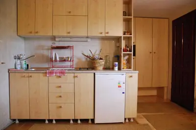 a kitchen with wooden cabinets and a white refrigerator at Studio za dvoje u Planinskoj kući Savić in Kopaonik